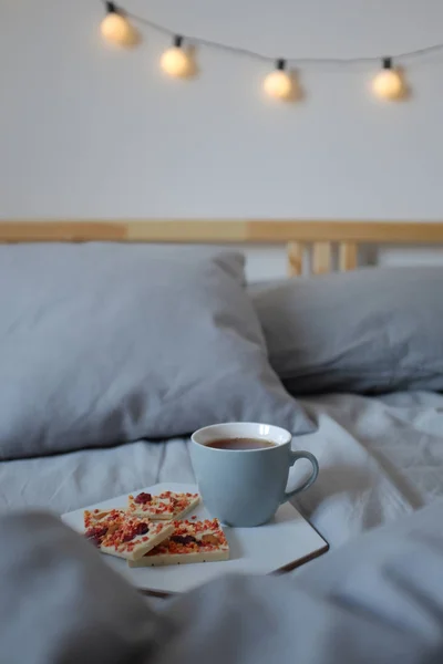 Petit déjeuner au lit. Tasse de thé et chocolat blanc — Photo