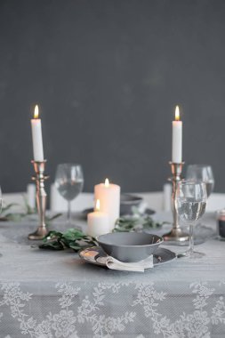 Tablo ayarı. Mumlar, tabak ve bardak