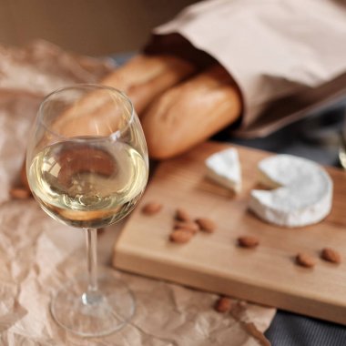Bir kadeh beyaz şarap ve peynir bir kara tahta üzerinde