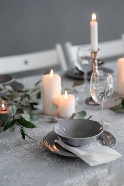 Tablo ayarı. Mumlar, tabak ve bardak
