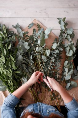 Çiçekçi bir buket yapar. İş süreci. Yukarıdan görüntülemek