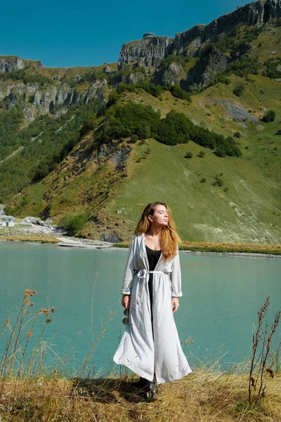 Una chica está junto a los lagos en el fondo de las montañas — Foto de Stock
