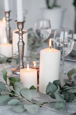Mumları masanın üzerinde. Düğün ya da Festival Tablo ayarı. Tabaklar, şarap gözlük, mumlar ve çatal bıçak takımı