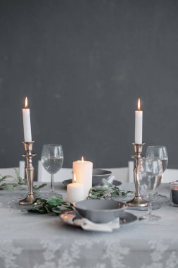 Tablo ayarı. Mumlar, tabak ve bardak