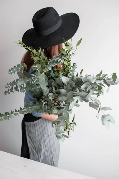 Florist makes a bouquet. Process of work. woman holding a bouquet of eucalyptus in hands