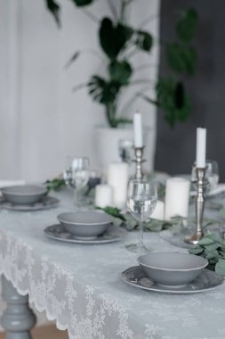 Düğün ya da şenlik masası. Tabaklar, şarap bardakları, mumlar ve çatal bıçak takımı.