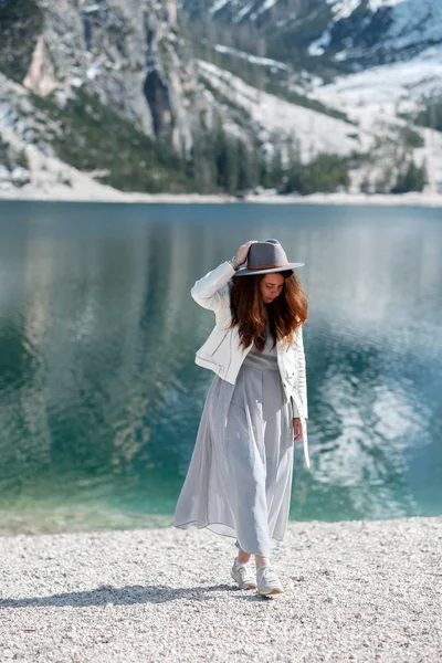 Una chica con un sombrero y un vestido largo está caminando por el lago. Lago di Bries en el norte de Italia — Foto de Stock