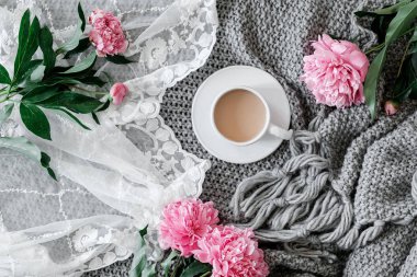 Bir fincan kahve ve gri arka plan üzerinde peonies