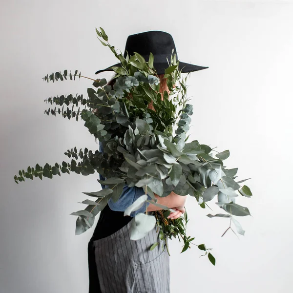 Florist makes a bouquet. Process of work. woman holding a bouquet of eucalyptus in hands