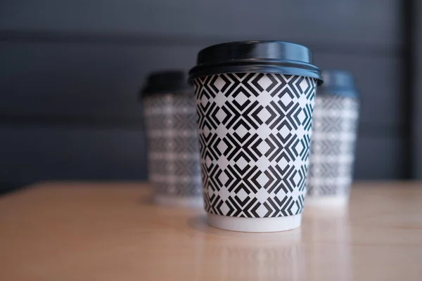 plastic disposable coffee cups on wooden background