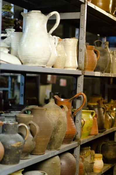 metal shelving with old ceramic jugs on shelves