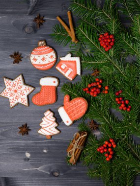 Ahşap zemin üzerinde ladin dalları arasında zencefilli kurabiye seti