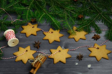 Ahşap zemin üzerinde ladin dalları arasında zencefilli kurabiye seti