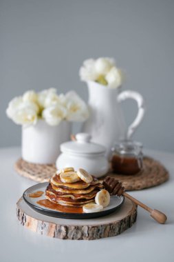Masanın üstünde ballı ve muzlu leziz krepler.