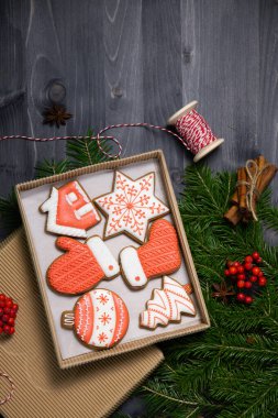 Ahşap zemin üzerinde ladin dalları arasında zencefilli kurabiye seti