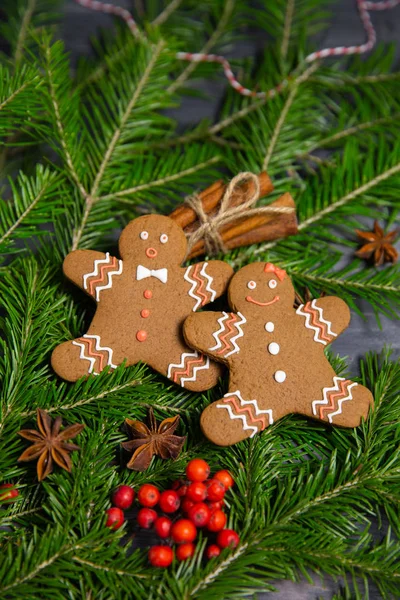 set of christmas gingerbread cookies among spruce branches on wooden background