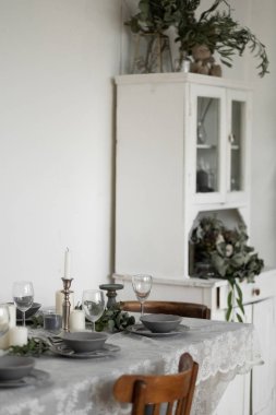Dining table served for guests with festive candles and grey utensil