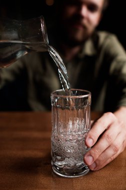 Bearded man drinking alcohol alone sitting at table