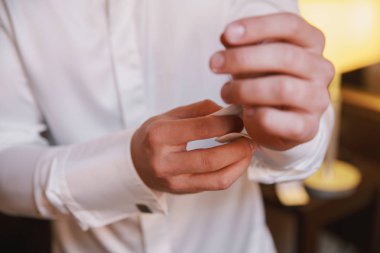 Close view of man buttoning shirt