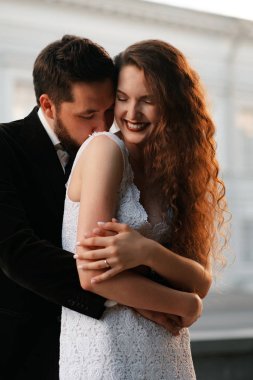 Bulanık şehir arka bahçesinde poz veren güzel yeni evli çift.