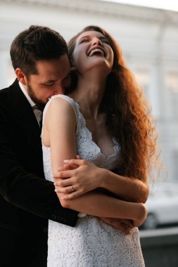 Bulanık şehir arka bahçesinde poz veren güzel yeni evli çift.