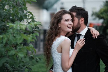 Bulanık şehir arka bahçesinde poz veren güzel yeni evli çift.