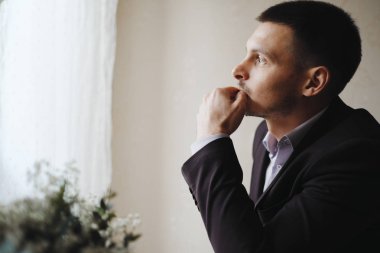 Thoughtful man in suit standing in room
