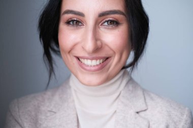 Odada poz veren esmer kadın.