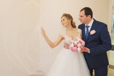 Sarışın gelin ve esmer damat birlikte poz veriyorlar.. 