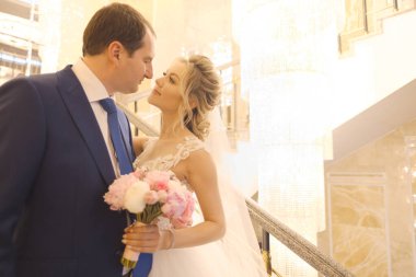 Sarışın gelin ve esmer damat birlikte poz veriyorlar.. 