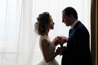 Odada poz veren yeni evlilerin yakın plan portresi.