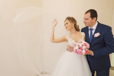 Sarışın gelin ve esmer damat birlikte poz veriyorlar.. 