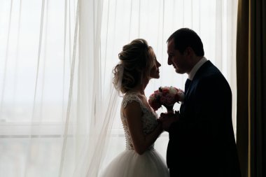 Odada poz veren yeni evlilerin yakın plan portresi.