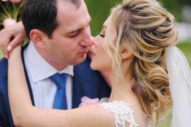 Güzel yeni evliler bahar parkında poz veriyorlar.