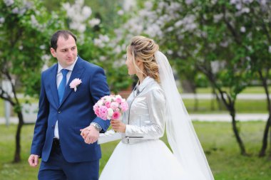 Güzel yeni evliler bahar parkında poz veriyorlar.