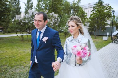 Baharda yeşil bahçede yürüyen yeni evliler