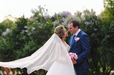 Güzel yeni evliler bahar parkında poz veriyorlar.