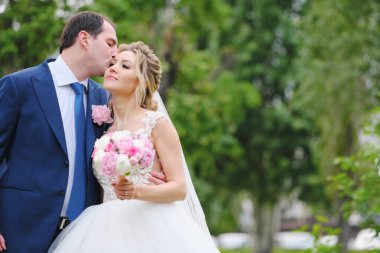 Güzel yeni evliler bahar parkında poz veriyorlar.