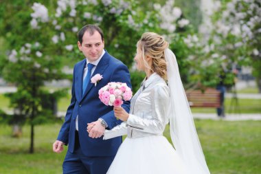 Güzel yeni evliler bahar parkında poz veriyorlar.