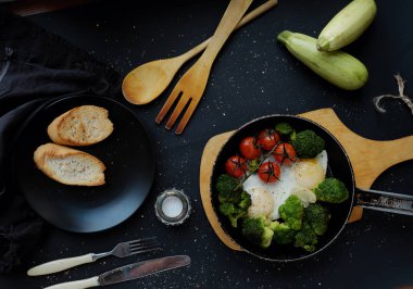 Brokolili yumurta ve tavada domates.