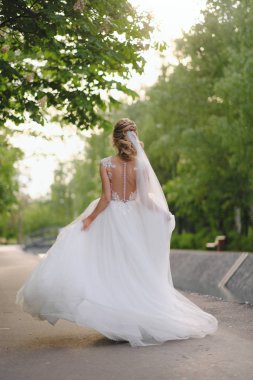 Güzel sarışın gelin bahar bahçesinde poz veriyor.