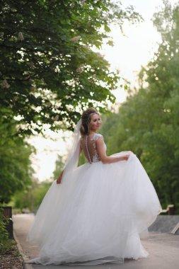 Güzel sarışın gelin bahar bahçesinde poz veriyor.