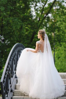 Güzel sarışın gelin bahar bahçesinde poz veriyor.