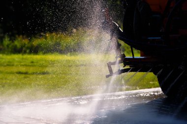 Close view of van spraying water on warm street in summer