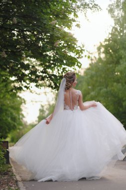 Güzel sarışın gelin bahar bahçesinde poz veriyor.