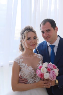 Odada poz veren yeni evlilerin portresi.