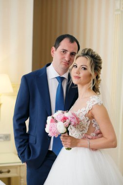 Odada poz veren yeni evlilerin portresi.