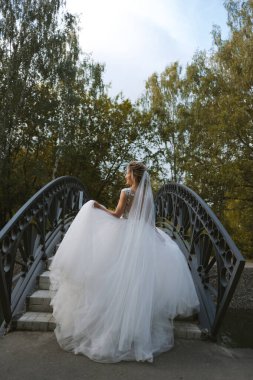 Güzel sarışın gelin bahar bahçesinde poz veriyor.