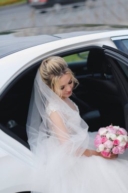 Güzel sarışın gelin arabadan çıkıyor.