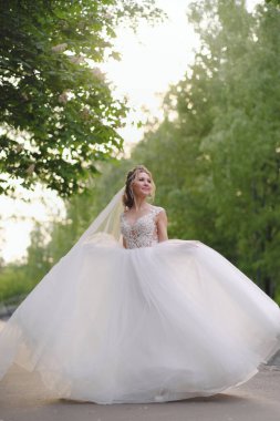 Güzel sarışın gelin bahar bahçesinde poz veriyor.